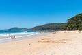 People enjoying the sunny weather at Pebbly Beach, a popular camping area with great surfing beach and bush walks within Royalty Free Stock Photo