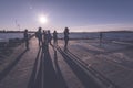 people enjoying sunset on the breakwater in the sea with lightho Royalty Free Stock Photo