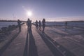 people enjoying sunset on the breakwater in the sea with lightho Royalty Free Stock Photo