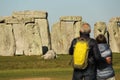 People enjoying view of Stonehenge, Neolithic ancient standing stone circle monument, UNESCO World Heritage Site