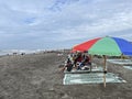 People enjoying the view under the umbrella on the beach Royalty Free Stock Photo