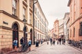 People walking and cycling on busy street in old  town Krakow. Royalty Free Stock Photo