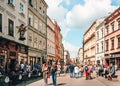 Couples and young families with children walking on busy street in old town Krakow. Royalty Free Stock Photo