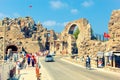 People enter the old town of Side through the ancient ruins of Vespasian monument