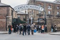 People entering Camden Market, London, UK, through the gates, under a name sign