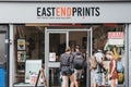 People entering East End Prints shop in East London, UK.