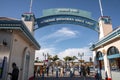 People at entrance of Santa Cruz Beach Boardwalk with under blue sky