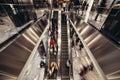 People on an escalator moving in the shopping mall to buy stuff in retail stores. Royalty Free Stock Photo