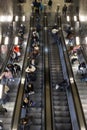 People on escalators in metro station, top view. Passengers crowd on escalators in subway