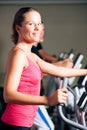 People exercising on elliptical trainer in gym