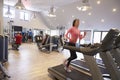 People exercising in a gym, blurred woman runs in foreground Royalty Free Stock Photo