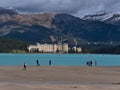 People exploring the shore of Lake Louise with turquoise water in front of the Rocky Mountains in Banff National Park, Canada. Royalty Free Stock Photo