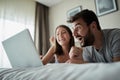 People, family, bedtime and fun concept -Couple with laptop in bed surfing on the net at laptop Royalty Free Stock Photo