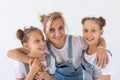 People, family and children concept - portrait of a lovely mother embracing her twin daughters on white background Royalty Free Stock Photo