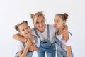 People, family and children concept - portrait of a lovely mother embracing her twin daughters on white background Royalty Free Stock Photo