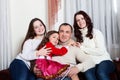 People family, christmas and adoption concept - happy mother, father and children hugging near a Christmas tree at home