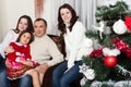 People family, christmas and adoption concept - happy mother, father and children hugging near a Christmas tree at home Royalty Free Stock Photo