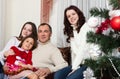 People family, christmas and adoption concept - happy mother, father and children hugging near a Christmas tree at home Royalty Free Stock Photo