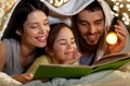 Happy family reading book in bed at night at home Royalty Free Stock Photo