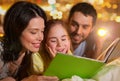 Happy family reading book in bed at night at home Royalty Free Stock Photo