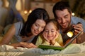 Happy family reading book in bed at night at home Royalty Free Stock Photo