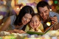 Happy family reading book in bed at night at home Royalty Free Stock Photo