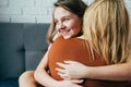 People and family concept - happy smiling girl with mother hugging on sofa at home.Happy mother`s day! Mom and her daughter child Royalty Free Stock Photo