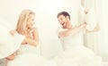 Happy couple having pillow fight in bed at home Royalty Free Stock Photo