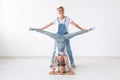 People, family and sport concept - young mom with twins daughters doing exercises on white background