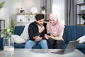 People, family and technologies concept. Happy young arabian muslim couple using app or social media on mobile phone at Royalty Free Stock Photo