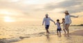 Happy family having fun running on a sandy beach at sunset time Royalty Free Stock Photo