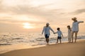 Happy family having fun running on a sandy beach at sunset time Royalty Free Stock Photo