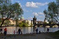 People feeding the swans on Vltava river bank