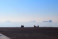 Silhouettes of people sitting at the seafront, Thessaloniki, Greece. Blue sea in mist Royalty Free Stock Photo