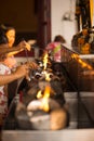 People fill oil on lantern in Wat Rakhang Khositaram