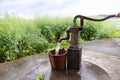 People filling bucket with water from Hand pump in hand-dig well in shallow aquifers in villages in countryside in China. Rapeseed Royalty Free Stock Photo