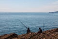 People fishing by cliffs