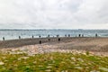 People fishing on danish shore of Oresund, outside the Kronborg castle. View of Swedish coast and Scandlines ferry boat