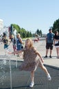 People at the fountain, abnormal heat in Russia. The girl enjoys the cold streams of water. Ulyanovsk, Russia, June 19