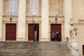 People in front of the Grand Theater building with wooden doors in Poznan, Poland. Royalty Free Stock Photo
