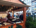 People fry grilled sausages on big hanging grill at Christmas market in Poznan Royalty Free Stock Photo