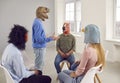 People in funny animal masks having a conversation during a group therapy session