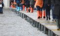 people in gaiters boots walking over elevated walkway during high tide Venice Italy Royalty Free Stock Photo