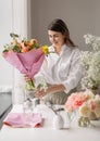 happy woman arranging flowers in vase at home Royalty Free Stock Photo