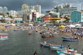 People gathered on a beach in Salvador with boats in front of them