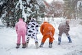 4 people, 2 girls and 2 mens in kigurumi in snow winter forest. Pajama costume pig cow kangaroo and cat. Fun with friends, walking Royalty Free Stock Photo