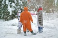 4 people, 2 girls and 2 mens in kigurumi in snow winter forest. Pajama costume pig cow kangaroo and cat. Fun with friends, walking Royalty Free Stock Photo