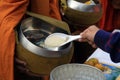 People gives polished rice offerings to a Buddhist monk