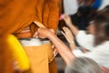 People giving donations for buddhist monk