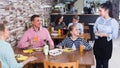 People are giving order to cheerful waitress Royalty Free Stock Photo